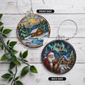 Double-sided acrylic Christmas ornament featuring a cozy winter cabin on the front and Santa Claus with a reindeer on the back, both in a stained-glass style reading "Merry Christmas."