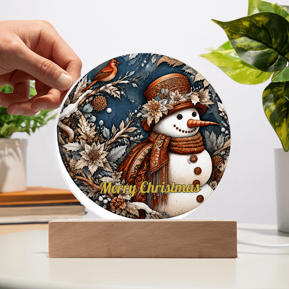 Hand placing a round snowman and red robin acrylic circle plaque onto a lighted wooden base.