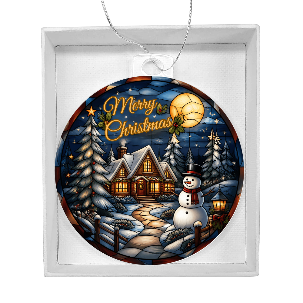 Round acrylic Christmas bulb ornament featuring a glowing winter cabin, snowman, and pine trees inside a white gift box.