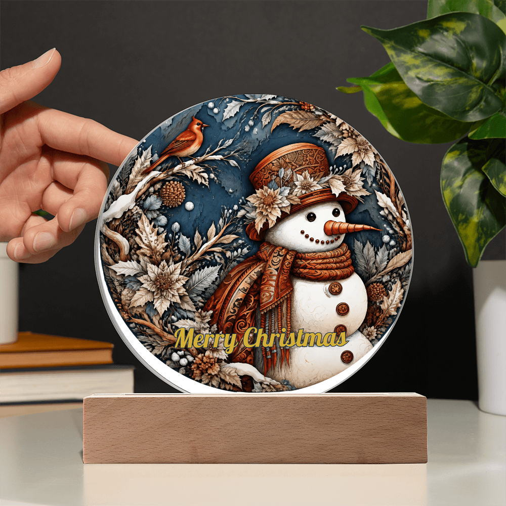 Hand placing a round snowman and red robin acrylic circle plaque onto a lighted wooden base.